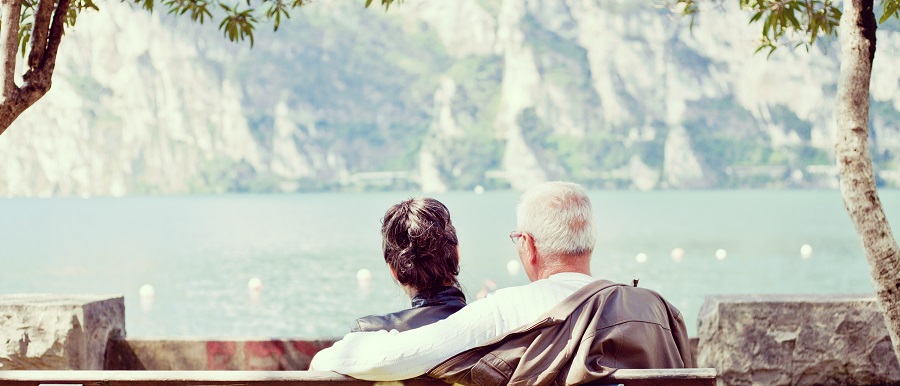 starsza para siedzi na ławce nad jeziorem